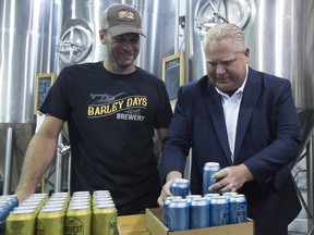 Ontario Premier Doug Ford and Barley Days brewery employee Kyle Baldwin pack some beer before the buck-a-beer plan announcement at Barley Days brewery in Picton, Ont., on Tuesday Aug. 7, 2018.