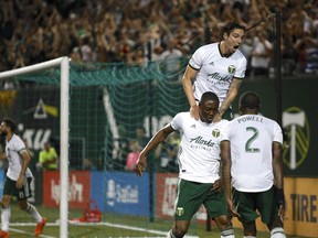 FILE - In this July 28, 2018, file photo, Portland Timbers' Fanendo Adi, second from right, celebrates with teammates after scoring a goal in the second half goal of an MLS soccer game against the Houston Dynamo in Portland, Ore. A fifteen-match unbeaten streak has moved the Timbers into second place in the Western Conference behind FC Dallas.