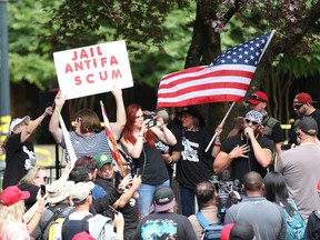FILE--In this June 30, 2018, file photo, the Patriot Prayer group holds a rally and march in Portland, Ore., amid a protest by anti-fascist groups. Portland is bracing for what could be another round of violent clashes Saturday, Aug. 4, 2018, between a right-wing group holding a rally here and self-described anti-fascist counter-protesters who have pledged to keep Patriot Prayer and other affiliated groups out of this ultra-liberal city.