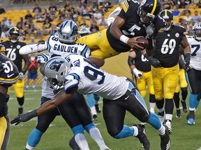 Pittsburgh Steelers quarterback Joshua Dobbs (5) leaps over Carolina Panthers defensive back Rashaan Gaulden (28) and defensive end Daeshon Hall (94) for a touchdown during the first half of a preseason NFL football game in Pittsburgh, Thursday, Aug. 30, 2018.