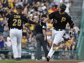 Pittsburgh Pirates' David Freese, right, is greeted by third base coach Joey Cora (28) as he rounds the bases after hitting a solo home run off St. Louis Cardinals starting pitcher Austin Gomber during the second inning of a baseball game, Saturday, Aug. 4, 2018, in Pittsburgh.
