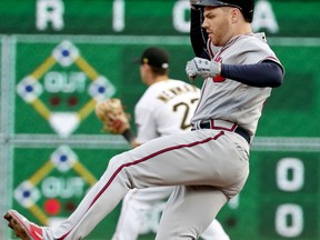 Atlanta Braves' Freddie Freeman, right, slides into second with a double as Pittsburgh Pirates' second baseman Kevin Newman, back  left, awaits the throw in the first inning of a baseball game Monday, Aug. 20, 2018, in Pittsburgh.