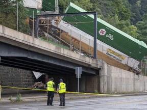 Emergency personnel work the scene of a train derailment above Carson Street on Sunday, Aug. 5, 2018, near Station Square in Pittsburgh. Four cars from a freight train derailed in Pittsburgh, sending containers tumbling down a hillside onto light rail tracks below, but no injuries have been reported, authorities said.