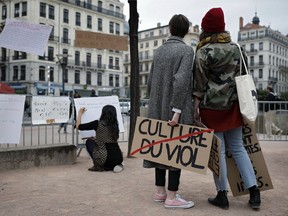 FILE - In this Oct. 29, 2017 file photo, a woman holds a banner that reads: 'Rape Culture' during a demonstration in Lyon, central France, to support the wave of testimonies denouncing cases of sexual harassment. French lawmakers have voted Wednesday Aug. 1, 2018 to expand the definition of child rape and to outlaw sex harassment on the street.
