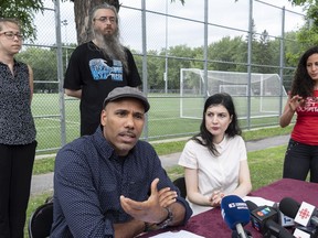 Will Prosper, Josianne Barrette Moran, sitting, and other supporters hold a news conference in Montreal, on Wednesday, August 1, 2018 next to the park where Fredy Villanueva, a teenager who was shot dead by Montreal police on Aug. 9, 2008.