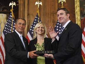 FILE - In this Jan. 5, 2011, file photo, House Speaker John Boehner of Ohio, left, administers the House oath to Rep. Duncan Hunter, R-Calif., as his wife, Margaret, looks on during a mock swearing-in ceremony on Capitol Hill in Washington. A federal grand jury in California on Tuesday, Aug. 21, 2018, has indicted U.S. Rep. Duncan Hunter and his wife on corruption charges.