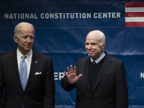 FILE - In this Oct. 16, 2017, file photo, Sen. John McCain, R-Ariz., right, accompanied by Chair of the National Constitution Center's Board of Trustees, former Vice President Joe Biden, waves as he takes the stage before receiving the Liberty Medal in Philadelphia. McCain's body lies in state Wednesday, Aug. 29, 2018, at the Capitol in Arizona, his home state.