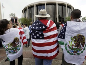 FILE - In this June 26, 2017, file photo, protesters take part in a rally to oppose a new Texas "sanctuary cities" bill that aligns with the president's tougher stance on illegal immigration, in San Antonio, Texas, outside of the Federal Courthouse. A U.S. appeals court says President Donald Trump's executive order threatening to withhold funding from "sanctuary cities" that limit cooperation with immigration authorities is unconstitutional. But the 9th U.S. Circuit Court of Appeals on Wednesday, Aug. 1, 2018, said a lower court went too far when it blocked the order nationwide.