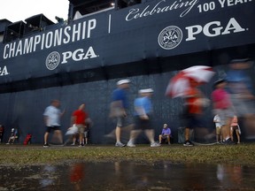 Patrons leave the course as play was suspended for the rest of the day during the second round of the PGA Championship golf tournament at Bellerive Country Club, Friday, Aug. 10, 2018, in St. Louis. Play was suspended due to heavy rains.