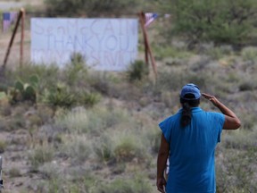A military veteran pays his respects, as John McCain has discontinued medical treatment for an aggressive form of brain cancer, at the entrance to the McCain ranch complex in Cornville, Ariz., Saturday, Aug. 25, 2018. Arizona Sen. McCain, the war hero who became the GOP's standard-bearer in the 2008 election, has died. He was 81. His office says McCain died Saturday, Aug. 25, 2018. He had battled brain cancer.