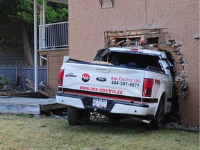 Scene of a crash where a baby was injured and sent to hospital after becoming trapped under a pickup truck that smashed through a house in Surrey.