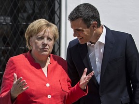 Spain's Prime Minister Pedro Sanchez, right, speaks with German Chancellor Angela Merkel at the Guzmanes Palace in Sanlucar de Barrameda, southern Spain, Saturday Aug. 11, 2018, prior to talks at the Donana National Park.
