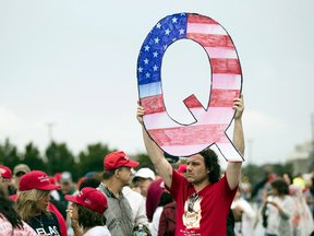 David Reinert holding a Q sign waits to enter a campaign rally with President Donald Trump on Aug. 2, 2018, in Wilkes-Barre, Pennsylvania.