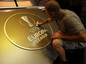 A worker gives the final touch before the UEFA Europa League draw at the Grimaldi Forum, in Monaco, Friday, Aug. 31, 2018.