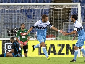 Lazio's Ciro Immobile, center, celebrates with his teammate Marco Parolo after scoring the Serie A soccer match between Lazio and Napoli at the Rome Olympic stadium Saturday, Aug. 18, 2018.