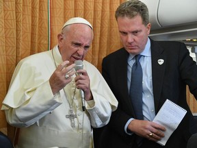 FILE - In this Sunday, Oct. 2, 2016 file photo, Pope Francis is flanked by Vatican Spokesman Greg Burke as he speaks with journalists on board the flight from Baku to Rome. The Vatican has called the sex abuse described in a grand jury report in Pennsylvania "criminal and morally reprehensible." In a statement released late Thursday, Aug. 16, 2018 Vatican spokesman Greg Burke said "those acts were betrayals of trust that robbed survivors of their dignity and faith." He said that victims should know that Pope Francis is on their side.