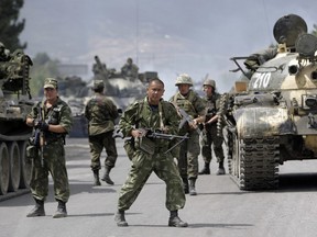 In this file photo taken on Thursday, Aug. 14, 2008, Russian soldiers block the road on the outskirts of Gori, northwest of the capital Tbilisi, Georgia.