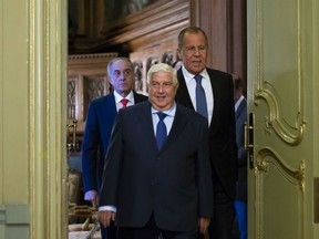 Syrian Foreign Minister Walid Muallem, center, and Russian Foreign Minister Sergey Lavrov, right, enter a hall for their joint news conference followed their talks in Moscow, Russia, Thursday, Aug. 30, 2018. Muallem's Moscow visit comes as Moscow and Damascus are increasingly worried about a possible airstrike on government positions in Syria.