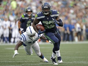 Seattle Seahawks running back Chris Carson (32) outruns a tackle-attempt by Indianapolis Colts linebacker Skai Moore during the first half of an NFL football preseason game, Thursday, Aug. 9, 2018, in Seattle.