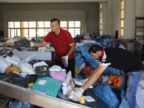 Palestinian postal workers sift through eight years' worth of undelivered mail held by Israel, at the post office in the West Bank city of Jericho, Sunday, Aug. 19, 2018. In recent days the postal staff has been sorting through tons of undelivered mail in a room packed with letters, boxes and even a wheelchair. Postal official Ramadan Ghazawi says Israel did not respect a 2008 agreement to send and receive mail directly through Jordan. Israeli officials say the one-time release of 10.5 tons of mail was a "gesture."