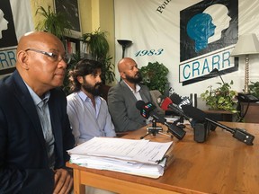 Julian Menzes, centre, is joined by Fo Niemi, left, the director of executive director of the Center for Research-Action on Race Relations (CRARR) and Alain Babineau, a law intern specializing in racial profiling with the group, at a news conference in Montreal on Tuesday, Aug. 21, 2018. In June, Menezes concluded a $25,000 settlement with the city over a racial profiling incident where he was taken on a so-called starlight tour before being dumped by police far from home.