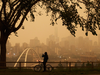 A morning commuter stops to take a photo of the city as smoke from the B.C. wildfires rolls in over Edmonton on Aug. 15, 2018.