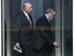 Australian Minister for Home Affairs Peter Dutton, left, leaves after a party room meeting at Parliament House in Canberra, Tuesday, Aug. 21, 2018. Australia's Prime Minister Malcolm Turnbull survived a leadership challenge, defeating Dutton in an internal government ballot that is unlikely to settle questions of his support.