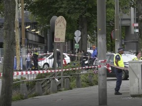 In this image made from video, Dutch police officers stand near the scene of a stabbing attack near the central daily station in Amsterdam, the Netherlands, Friday Aug. 31, 2018. Police the Dutch capital shot and wounded a suspect Friday following a stabbing at the central railway station. Amsterdam police said in a series of tweets that two people were injured in the stabbing and the suspect was then shot by officers.