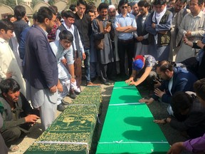 Relatives pray near to the dead bodies of civilians after Wednesday's deadly suicide bombing that targeted a training class in a private building in the Shiite neighborhood of Dasht-i Barcha, in western Kabul, Afghanistan, Thursday, Aug. 16, 2018.