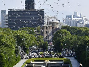 Doves fly over the cenotaph dedicated to the victims of the atomic bombing during a ceremony to mark the 73rd anniversary of the bombing at Hiroshima Peace Memorial Park in Hiroshima, western Japan, Monday, Aug. 6, 2018. The Atomic Bomb Dome is seen in center background.