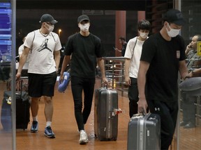 Four Japanese basketball players arrive at Jakarta airport Monday, Aug. 20, 2018. They were kicked off their Asian Games team and sent home Monday after delegation head Yasuhiro Yamashita said they "spent the night in a hotel with women." Yamashita told a news conference that the four players hooked up with the women after eating and drinking and were easily identified by wearing Japan-emblazoned shirts in an entertainment district.