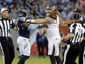 Officials break up Tennessee Titans linebacker Jayon Brown, left, and Tampa Bay Buccaneers offensive guard Ryan Jensen, right, in the first half of a preseason NFL football game Saturday, Aug. 18, 2018, in Nashville, Tenn.