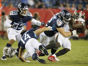 Tennessee Titans wide receiver Nick Williams (14) loses his helmet as he tries to bring down Tampa Bay Buccaneers running back Shaun Wilson, right, in the second half of a preseason NFL football game Saturday, Aug. 18, 2018, in Nashville, Tenn.