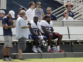 Tennessee Titans running backs Dion Lewis (33) and Derrick Henry (22) rest on a cooling bench during NFL football training camp Wednesday, Aug. 15, 2018, in Nashville, Tenn. The Titans put a bench on each side of their three practice fields, giving players a chance to recover when the temperature during morning practices can feel like 90 degrees.