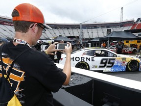 Dylan Timmons from Mansfield, Ohio takes a photo of Kasey Kahne's car during a track tour before a NASCAR Cup Series auto race, Saturday, Aug. 18, 2018, in Bristol, Tenn.