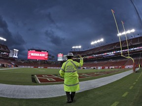 A Florida Highway Patrol trooper signals for everyone to clear the field during a weather delay before NFL football game between the Tampa Bay Buccaneers and the Detroit Lions Friday, Aug. 24, 2018, in Tampa, Fla.