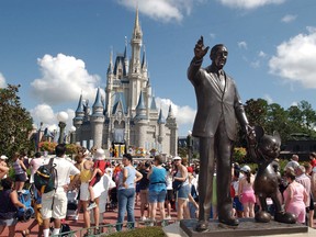 In this Sept. 2, 2004, file photo, tourists crowd around Cinderella's Castle to watch a performance at Walt Disney World's Magic Kingdom in Lake Buena Vista, Fla.