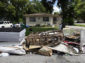 In this Aug. 9, 2018 photo, recently removed flood-damaged debris sits outside a home in Houston. Hurricane Harvey has been described as the storm that did not discriminate, damaging neighborhoods both rich and poor. But community and grassroots leaders say that a year after the storm, those having the hardest time recovering are residents who live in some of the poorest areas hit hardest by Harvey.