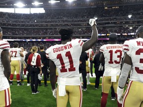 San Francisco 49ers wide receiver Marquise Goodwin (11) holds up a fist as he stands with teammates Kendrick Bourne (84) and Joe Williams (32) as the national anthem is played before an NFL preseason football game against the Houston Texans Saturday, Aug. 18, 2018, in Houston.