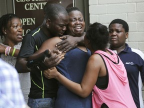 FILE - In this Aug. 4, 2018 file photo, the mother, center, of two young children is comforted after she found them stabbed to death in their father's apartment in Houston.  Court records show Jean Pierre Ndossoka, accused of killing his two children told authorities his 8-year-old son pleaded for mercy before having his throat cut. Ndossoka is charged with two counts of capital murder in deaths of his children, Marcel Ndossoka and 1-year-old Anna-Belle Faith Ndossoka.