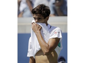 Pierre-Hugues Herbert, of France, wipes his face against Nick Kyrgios, of Australia, during the second round of the U.S. Open tennis tournament, Thursday, Aug. 30, 2018, in New York.
