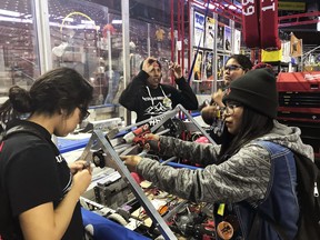 This March 3, 2018 photo provided by Heather Anderson shows, from left, Navajo Mountain High School students Nahida Smith, Myra King and Breana Bitsinne compete in a Utah regional robotics competition in West Valley City, Utah.  The team from a remote town in southern Utah is now headed to an international robotics competition Aug. 14 in Mexico City, Mexico.   They were invited to compete in the First Global Challenge, which will draw teams from 190 countries to create robots capable of feeding power plants and building environmentally efficient transmission networks.  (Heather Anderson via AP)