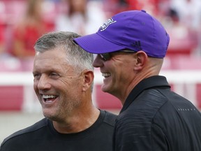 Utah coach Kyle Whittingham, left, and Weber State coach Jay Hill laugh before an NCAA college football game Thursday, Aug. 30, 2018, in Salt Lake City.