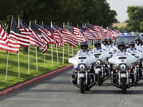 The funeral cortege for Battalion Chief Matt Burchett of the Draper Fire Department arrives at the Maverik Center in West Valley City, Utah,  on Monday, Aug. 20, 2018. Battalion Chief Matt Burchett was hit by a tree Monday while fighting a wildfire north of San Francisco. He was flown to a hospital where he succumbed to his injuries.