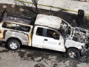 A burned West Valley City Community Preservation Code Enforcement vehicle is seen near the place where a structure fire and fatal shooting occurred in West Valley City, Utah, on Thursday, Aug. 9, 2018.