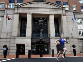 Cassie Semyon, 21, an intern for NBC News, runs from the courthouse with results outside of federal court as jury deliberations are announced in the trial of the former Donald Trump campaign chairman Paul Manafort in Alexandria, Va., Tuesday, Aug. 21, 2018.