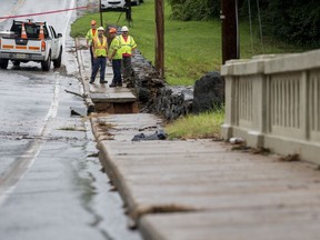 Workers from the City of Lynchburg and Wiley Wilson inspect College Lake Dam on Friday, Aug. 3, 2018 in Lynchburg, Va. Around 130 residents downstream of College Lake were evacuated the night before after a deluge on rain hit the area causing a fear of the dam failing.