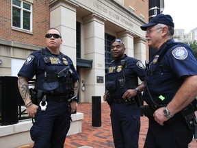 Security personnel from the Department of Homeland Security's Federal Protective Service, watch the vicinity around the Alexandria Federal Court in Alexandria, Va., on day one of Paul Manafort's trial, Tuesday, July 31, 2018.