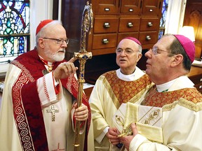 In this Feb. 14, 2014 file photo, from left, Sean Patrick Cardinal O'Malley, Archbishop of Boston; the Most Rev. Carlo Maria Vigano, apostolic nuncio to the United States, and the Most Rev. Robert Peter Deeley, prepare for the installation mass of Bishop Deeley at the Cathedral of the Immaculate Conception in Portland, Maine.