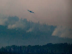 A tanker circles overhead before dropping retardant while battling the Shovel Lake wildfire near Fraser Lake, B.C. on Friday August 17, 2018.